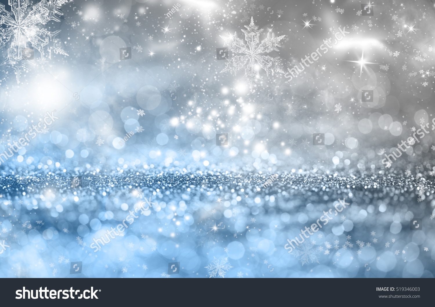Magic blue holiday abstract glitter background with blinking stars and falling snowflakes. Blurred bokeh of Christmas lights.