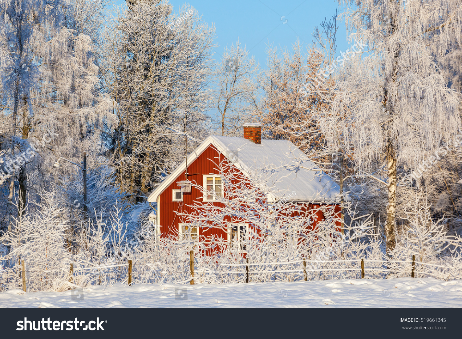 Red cottage in winter forest with frost and snow