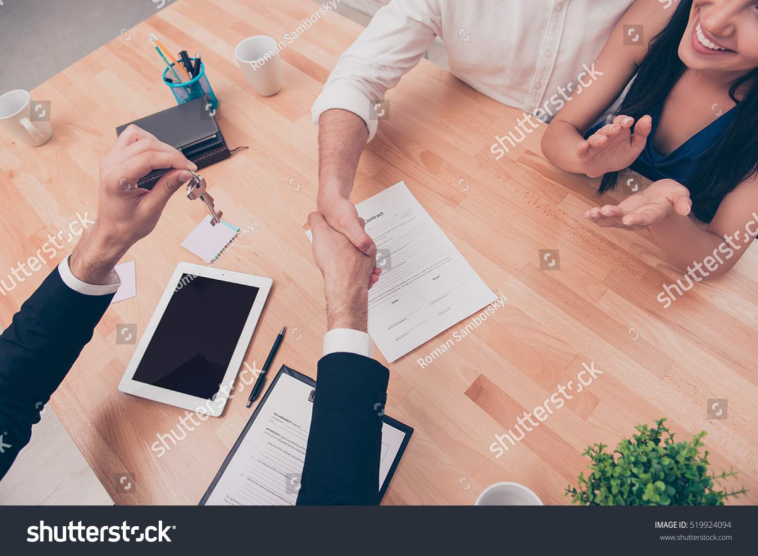 Broker giving keys of new house and handshaking with customer