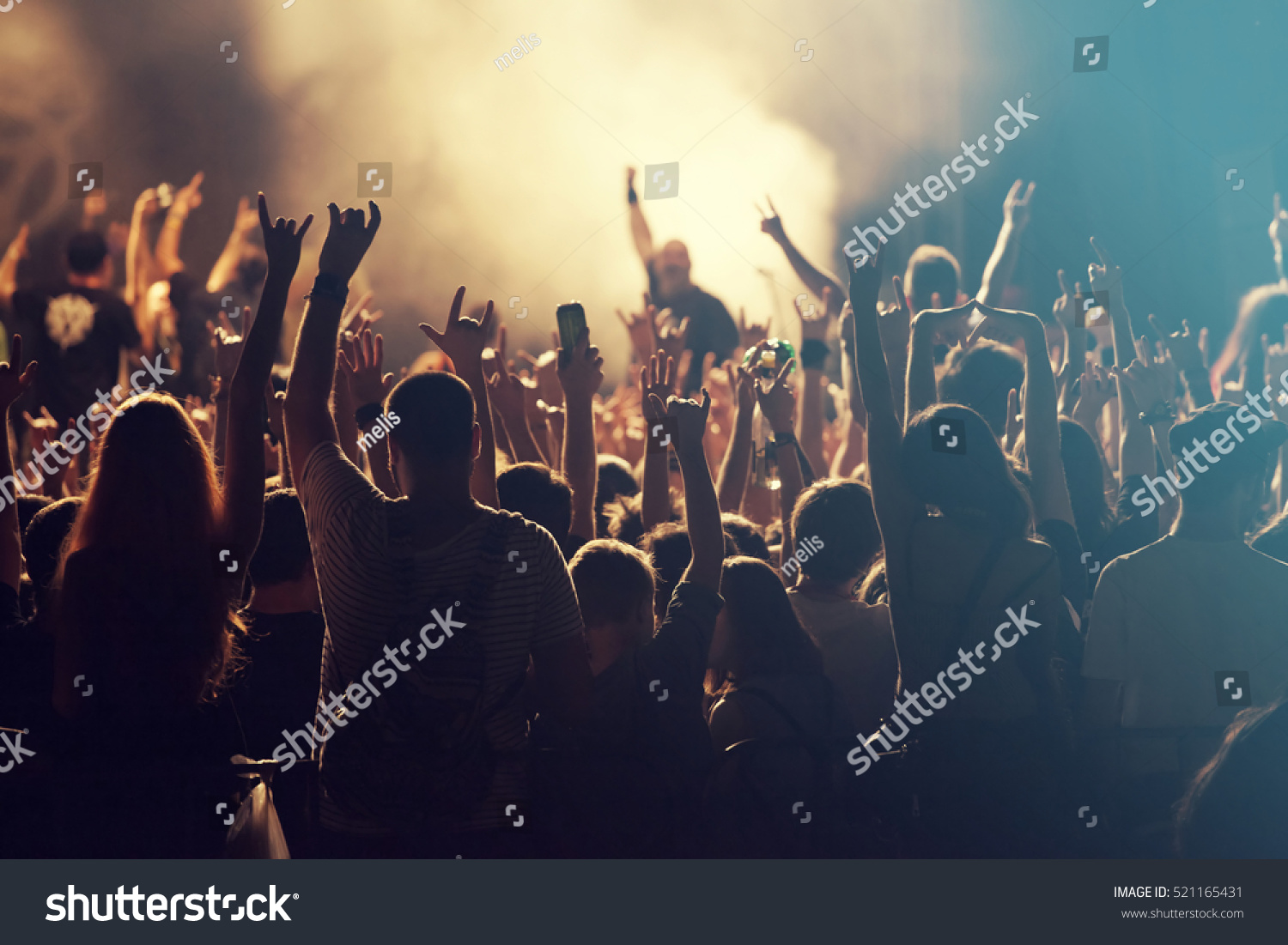 Crowd at concert - Cheering crowd in front of bright colorful stage lights