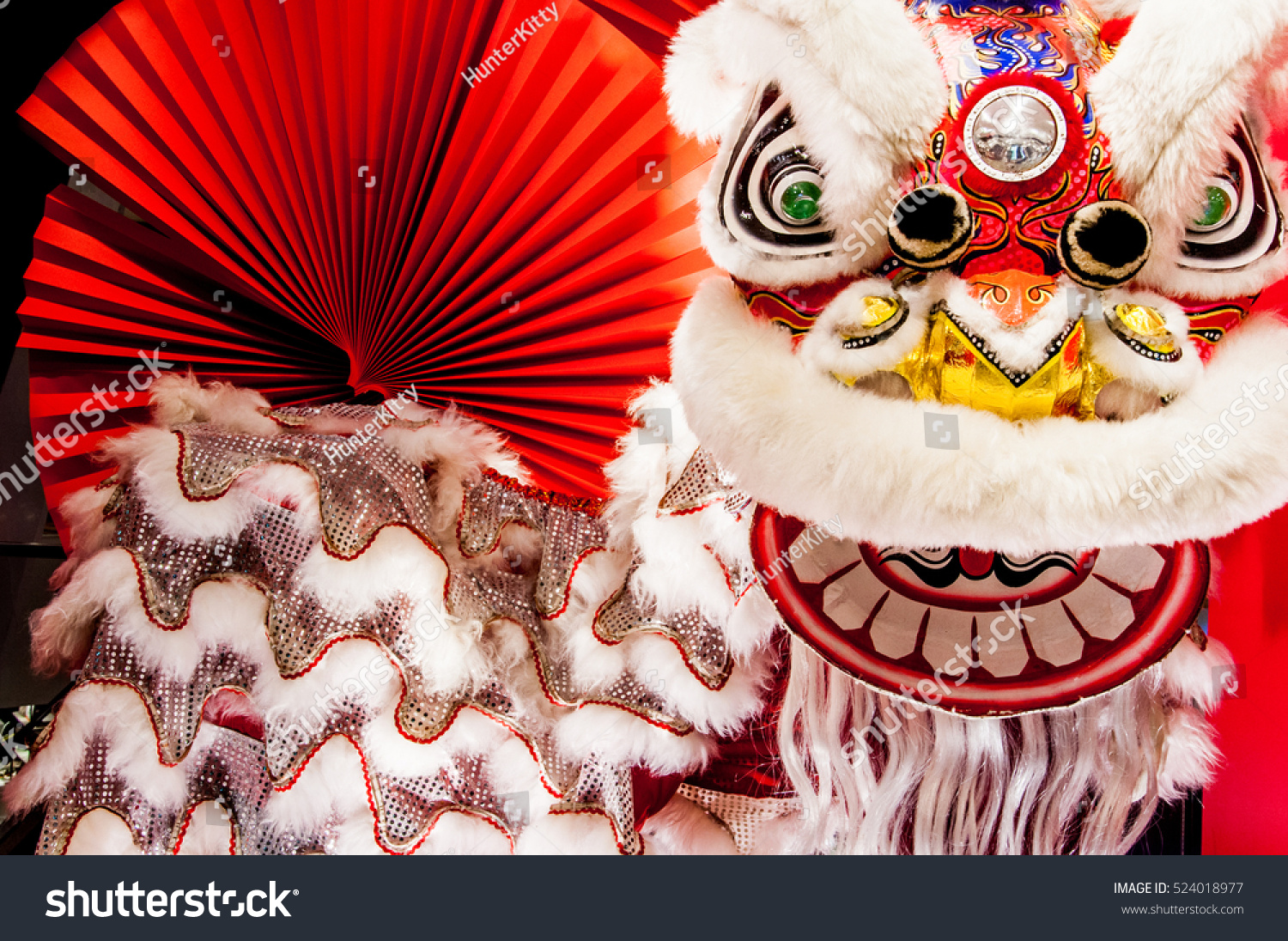 Chinese lion dance for Chinese new year with red fan in the background