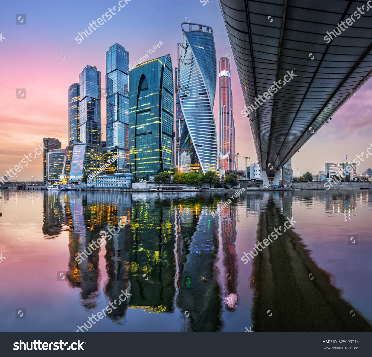 Skyscrapers in Moscow-City with reflection in the Moscow River in the sunset pink sky