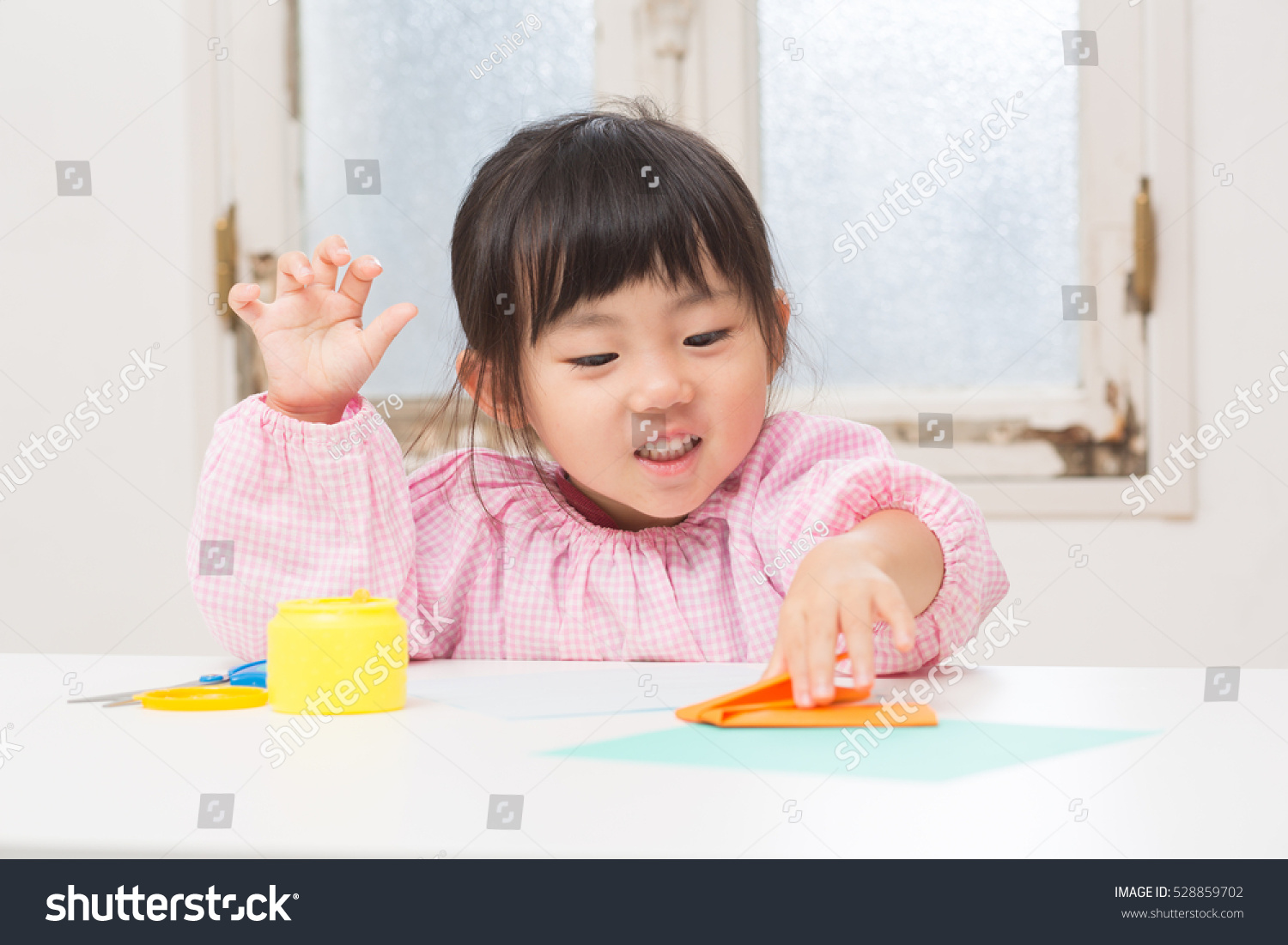 cute asian girl playing with origami