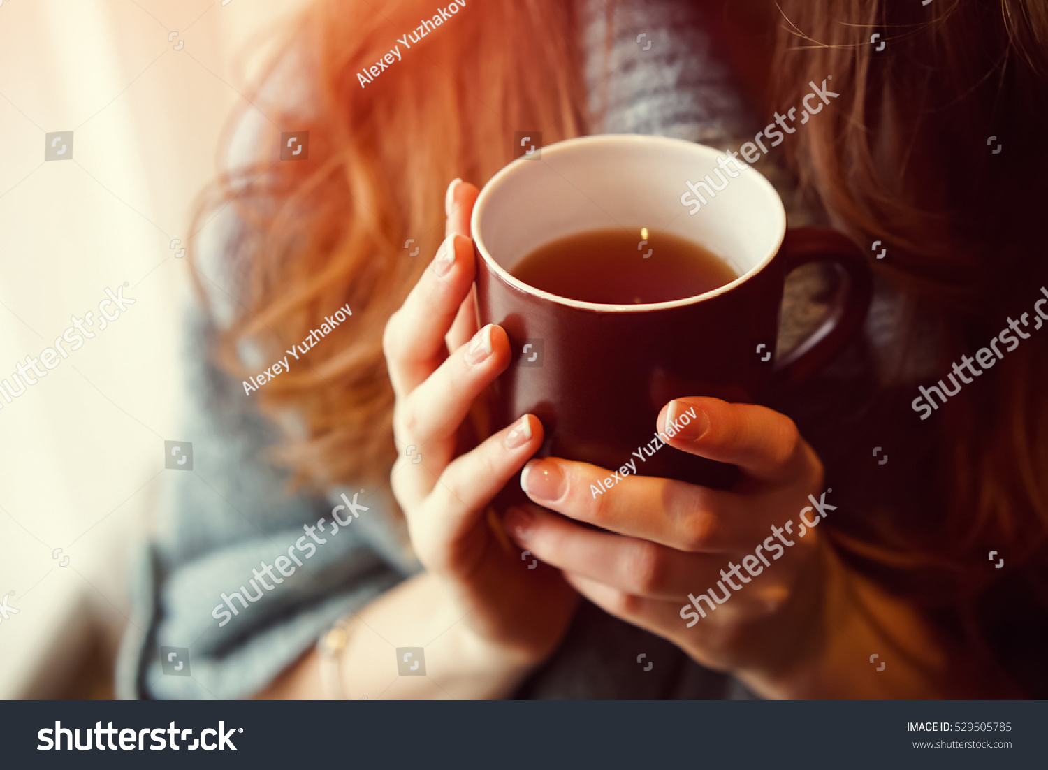 Drink Tea relax cosy photo with blurred background. Female hands holding mug of hot Tea in morning. Young woman relaxing tea cup on hand. Good morning Tea or Have a happy day message concept.