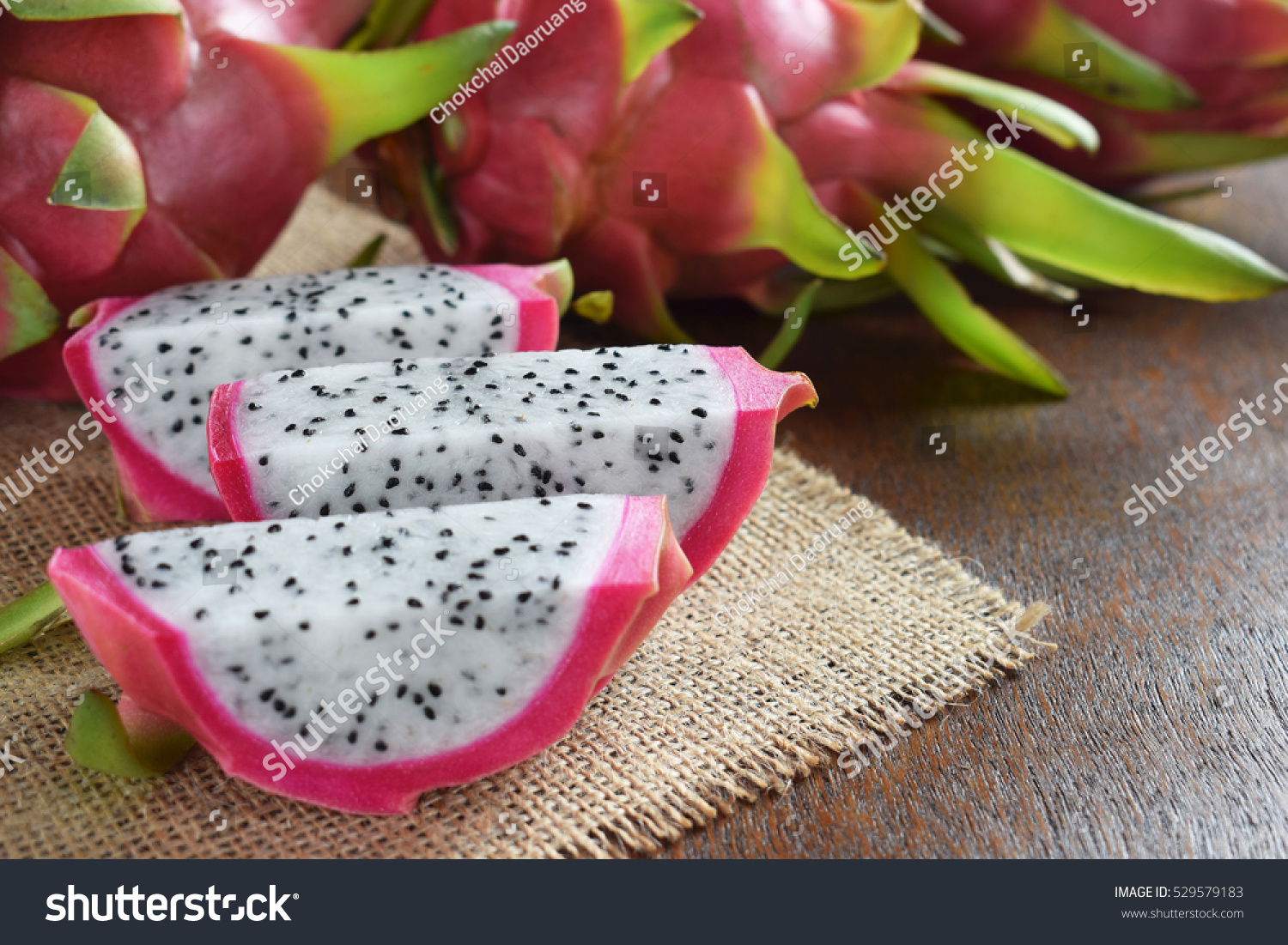 Healthy dragon fruits on sackcloth and brown wooden background
