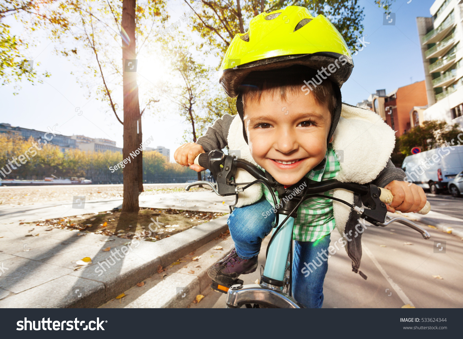 Smiling boy in safety helmet riding his bike