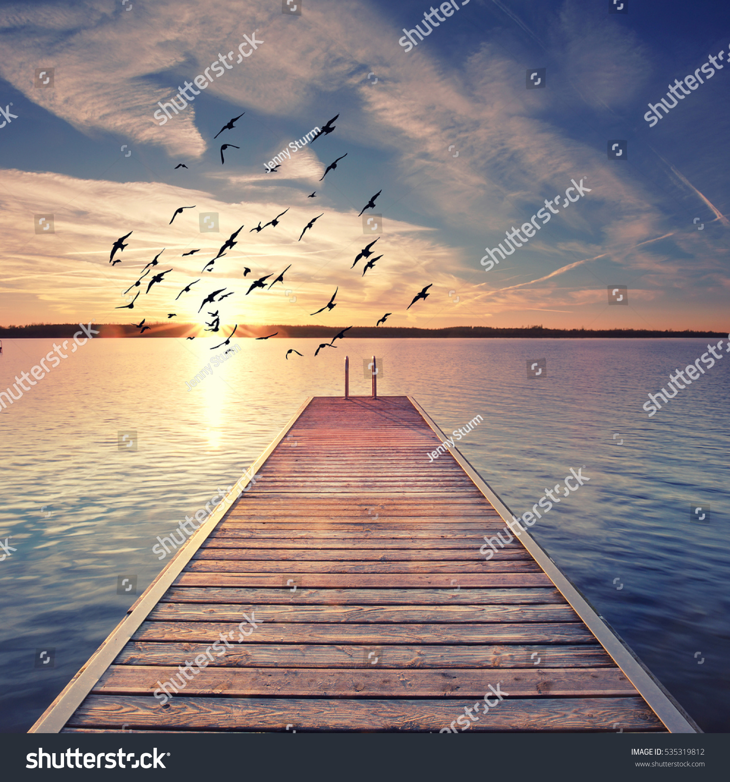 wooden Pier with stairway to water  sunset at the beach