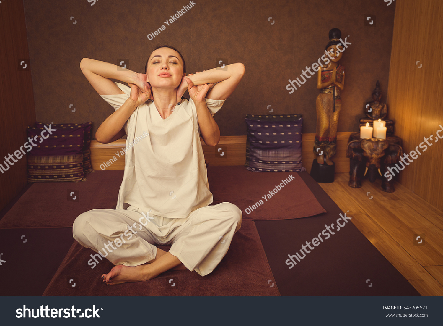 Calm girl stretching her body with masseur