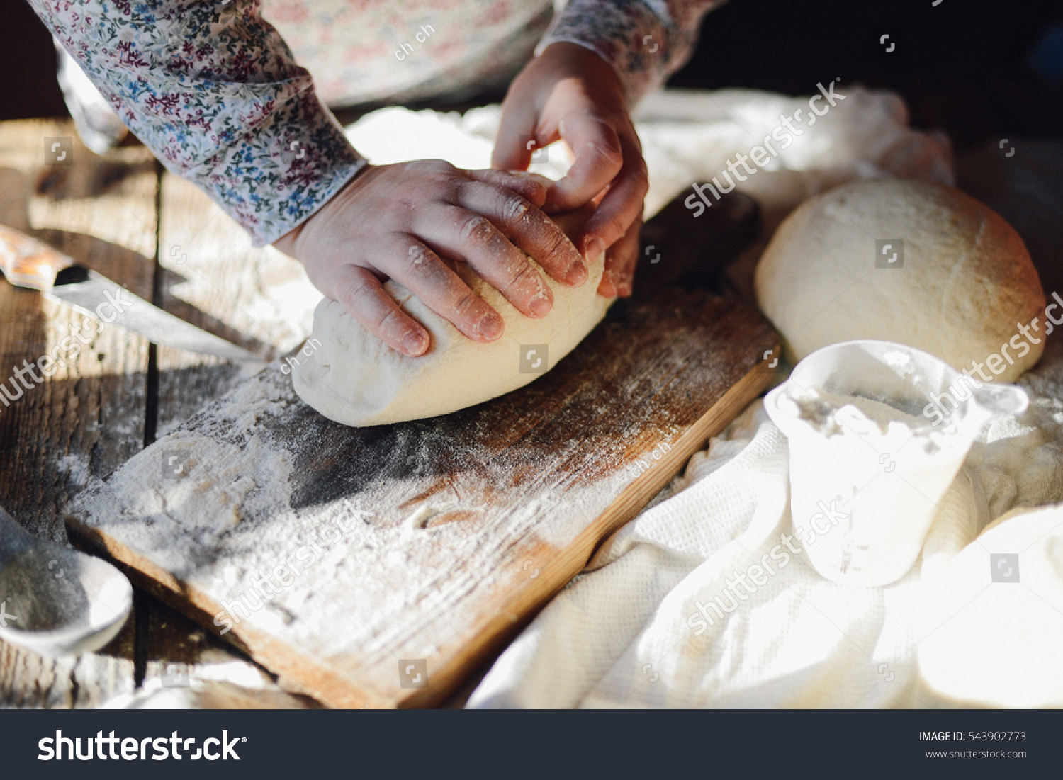 Close up view of baker kneading dough. Homemade bread. Hands preparing bread dough on wooden table. Preparing traditional homemade bread. Woman hands kneading fresh dough for making bread