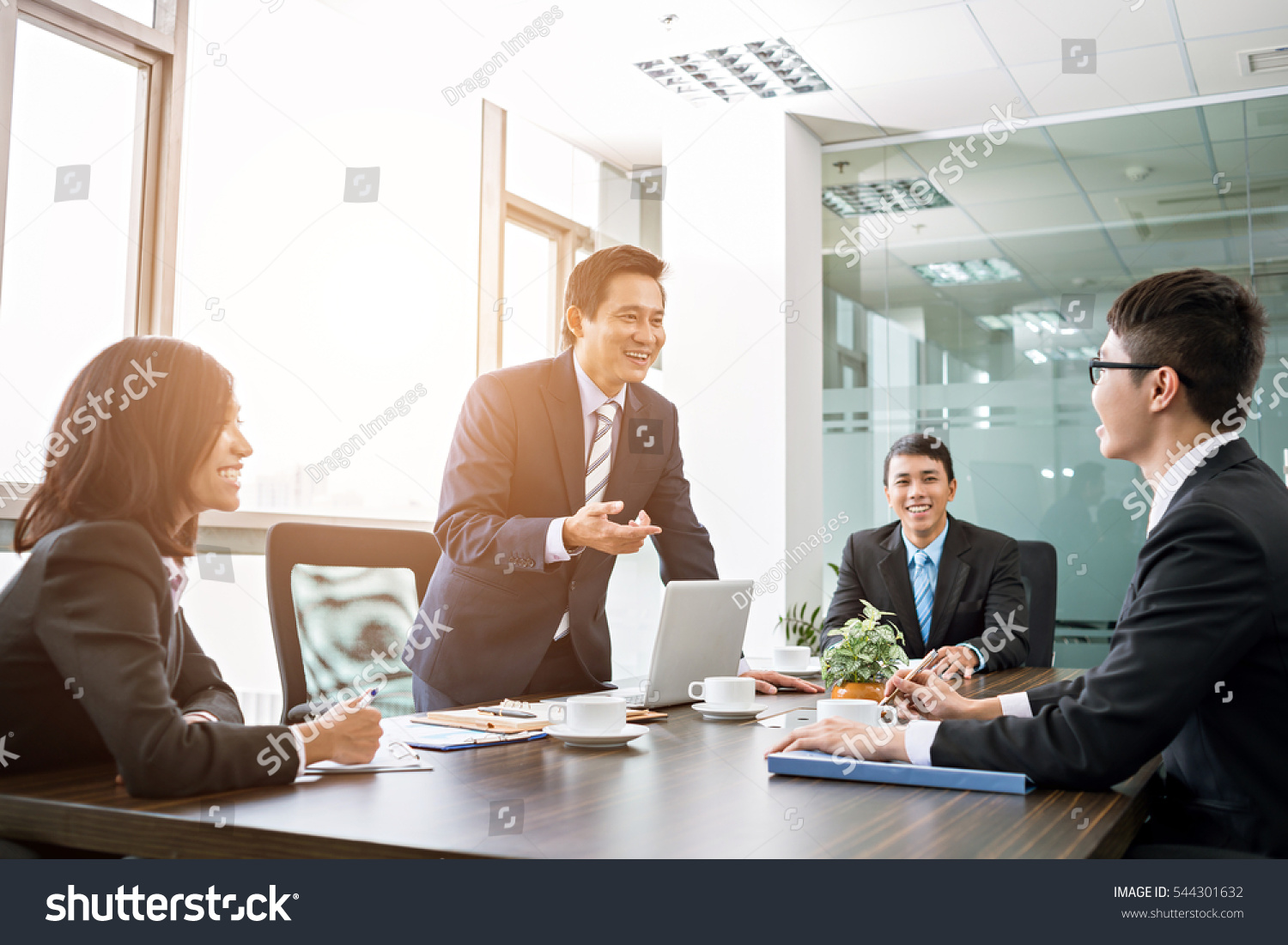 Positive Asian business team having meeting in office