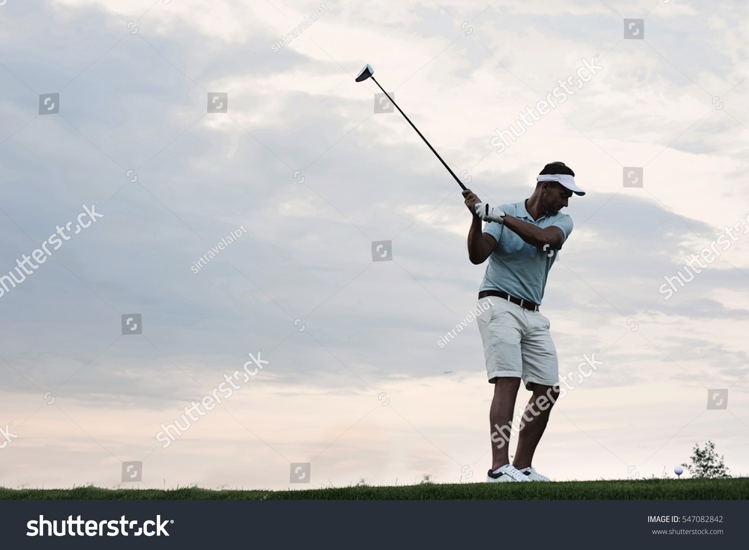 Mid-adult man playing golf against sky