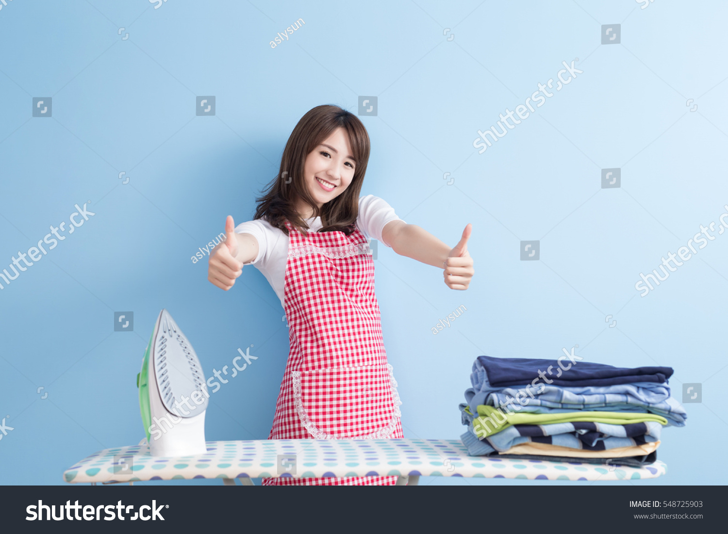 beauty housewife thumb up with ironing and shirt isolated on blue background