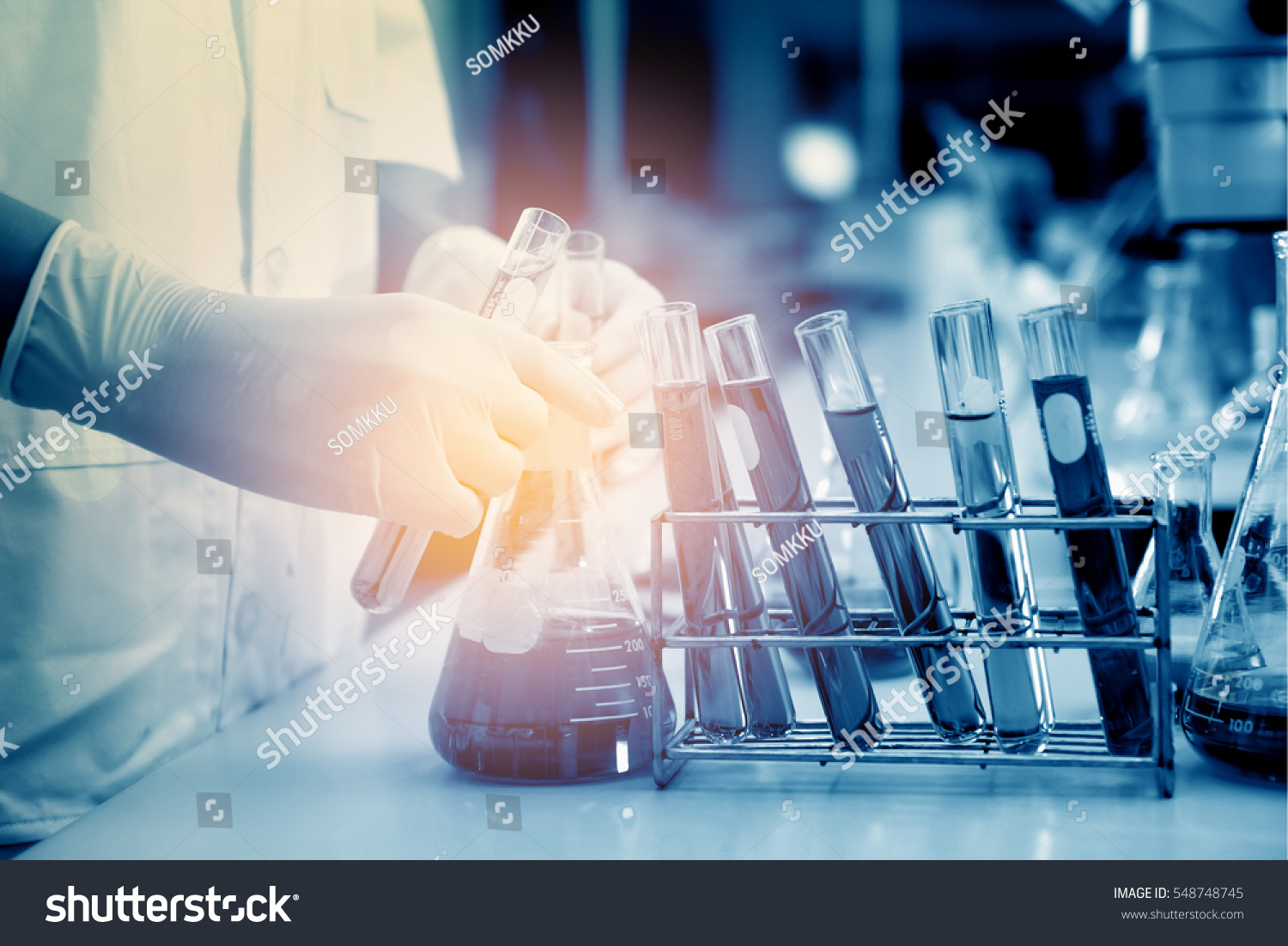 scientist hand holding laboratory test tube with soft focus