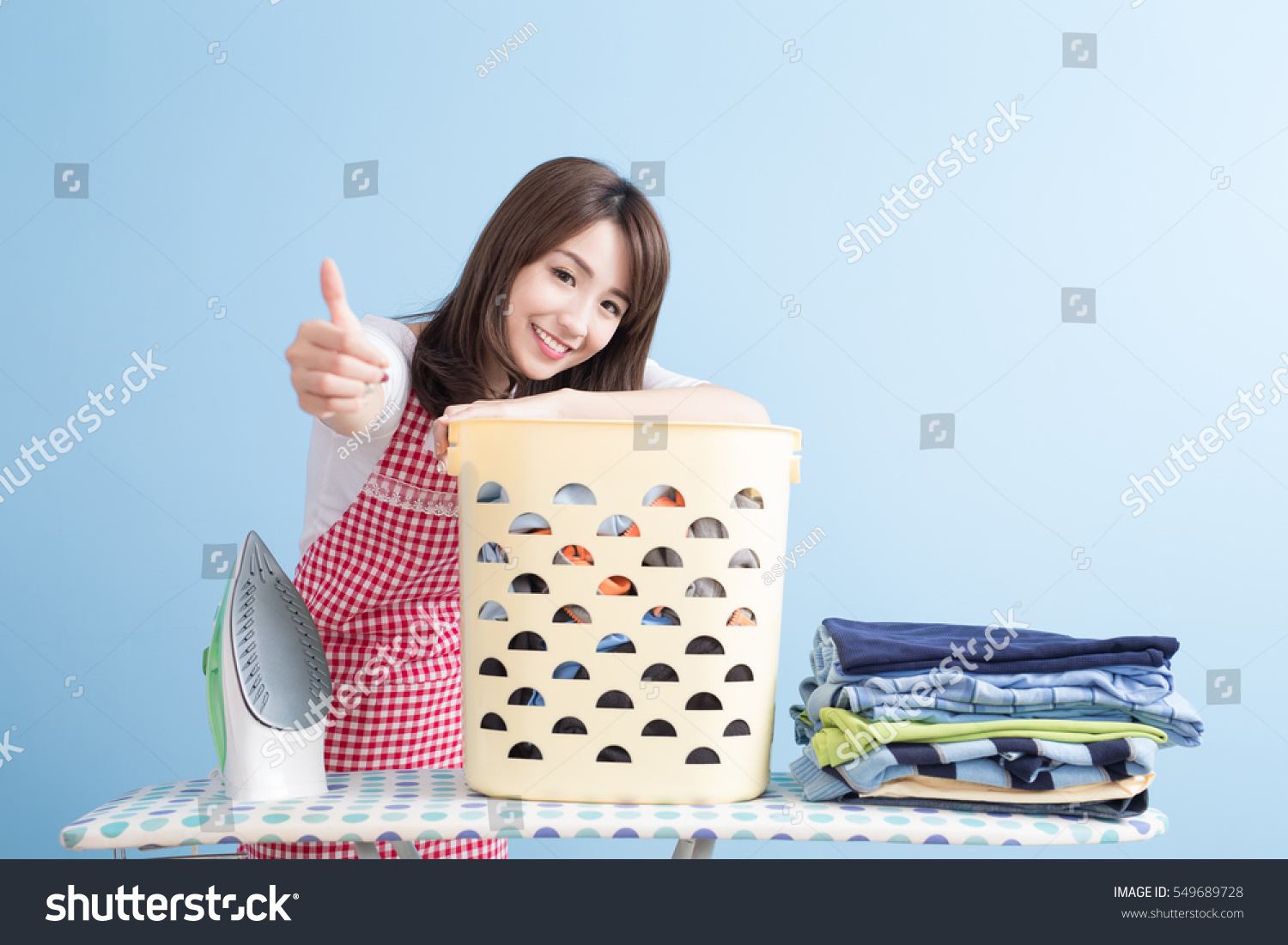 beauty housewife thumb up with ironing and shirt isolated on blue background