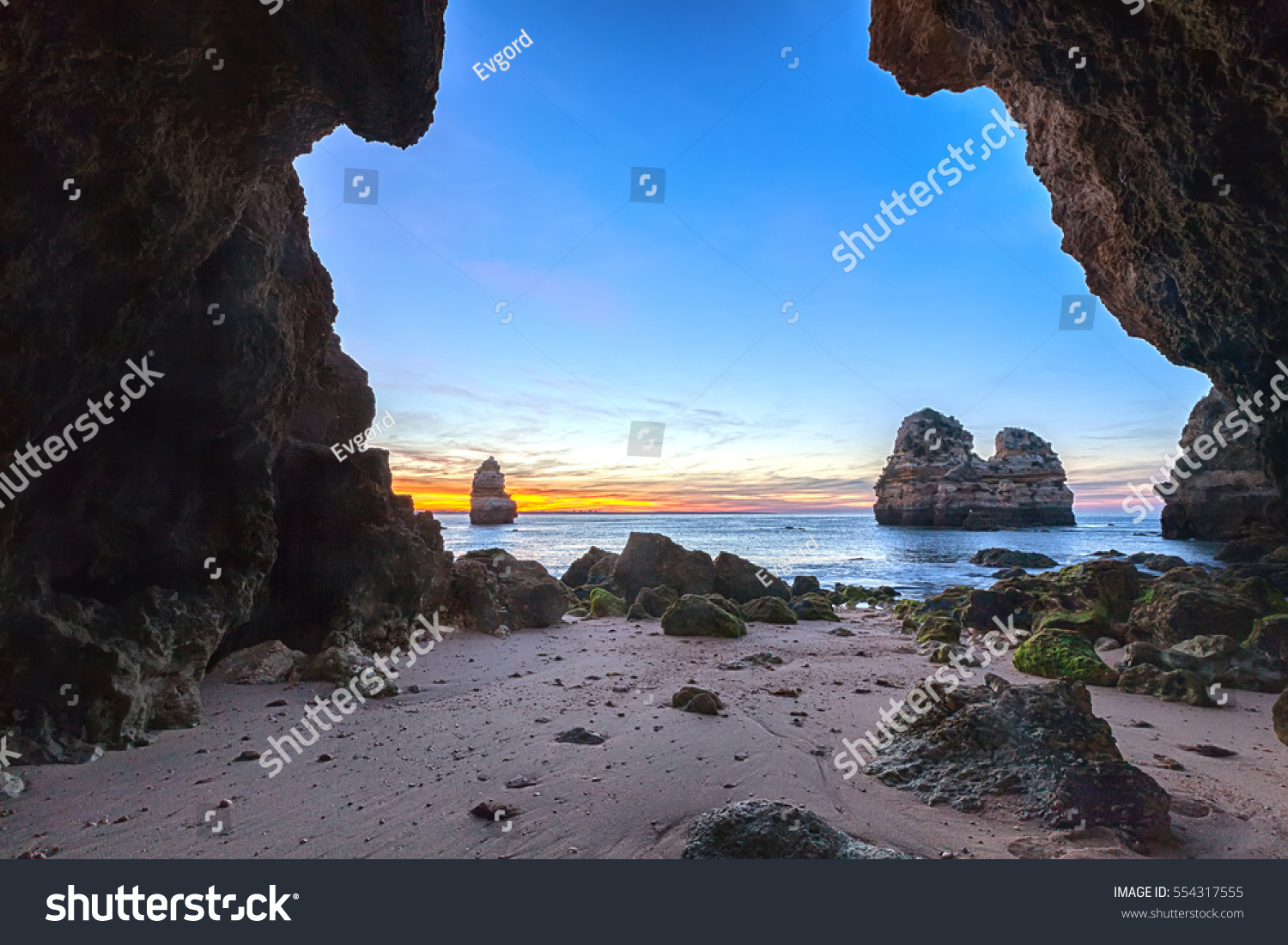 A cave arch by the sea at sunrise