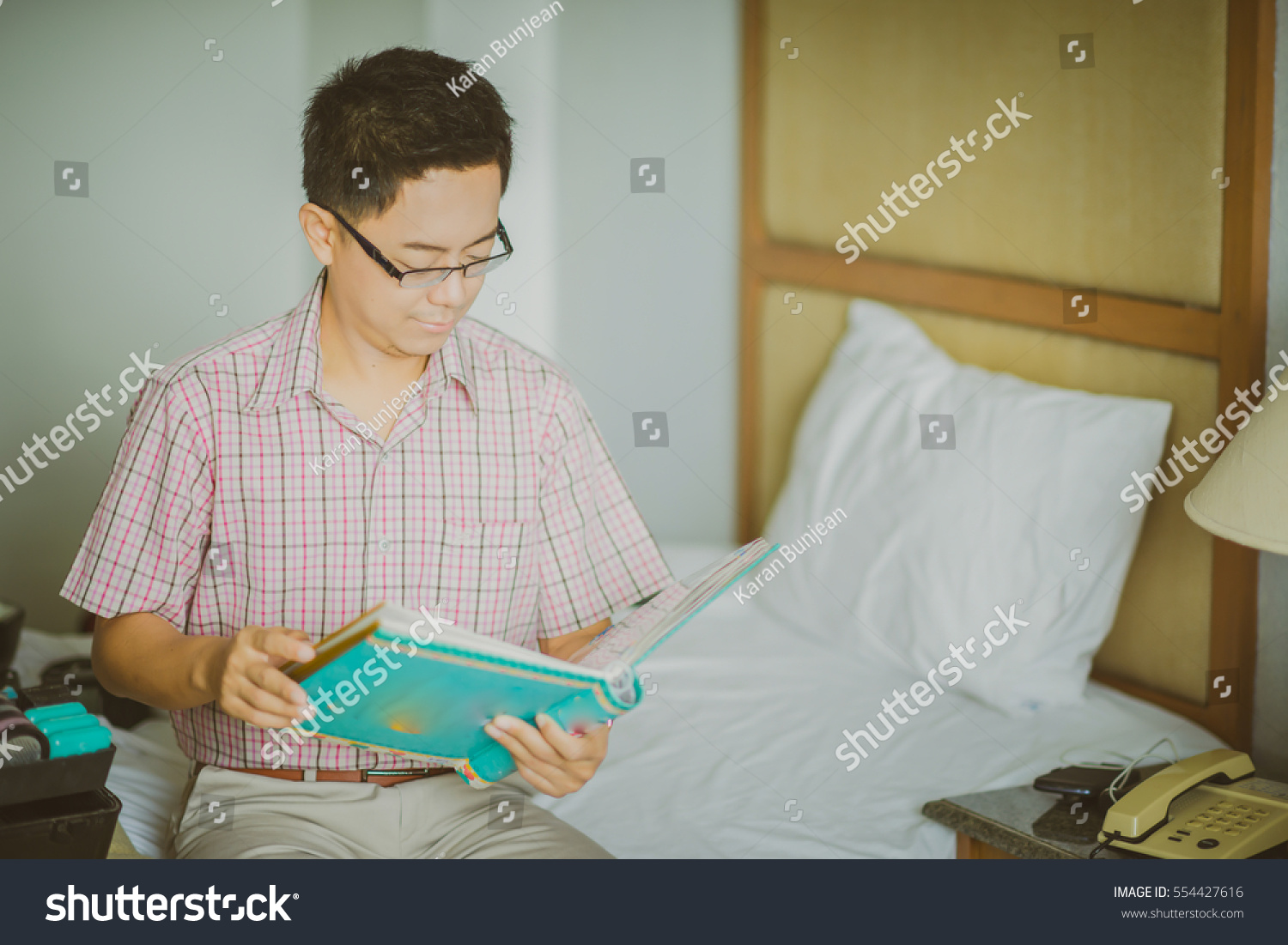 young asian business man reads a paper in his room before a conference 