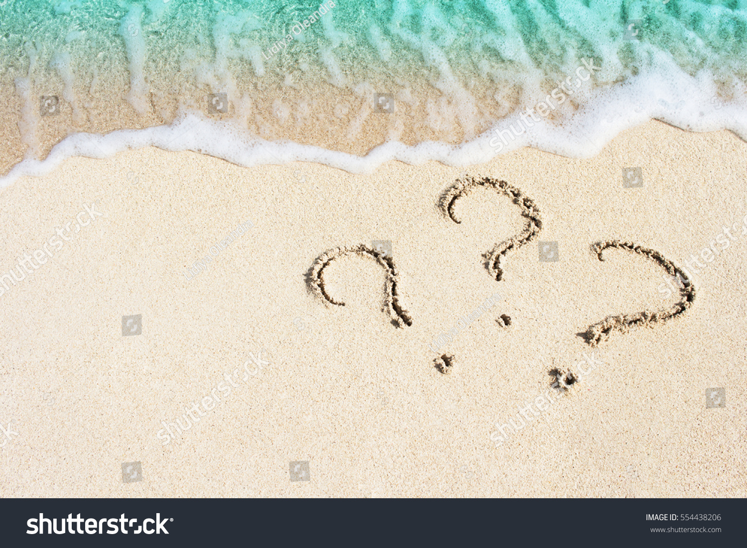 question mark sign handwritten in sand beach
