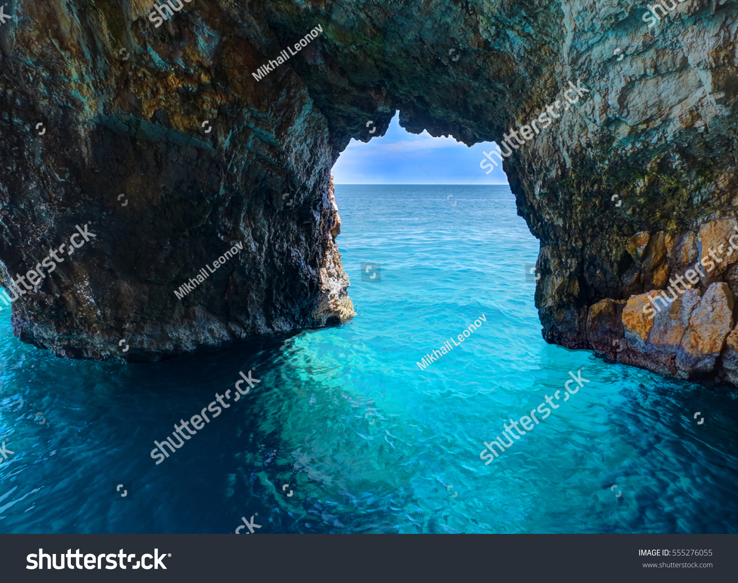 Beautiful view on rock arces arches of Blue caves from sightseeing boat with tourists in blue water of Ionian Sea inside cave  Island Zakynthos  Greece holidays vacation. Trip from Agios Nikolaos port