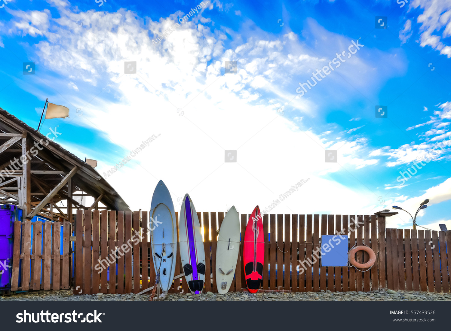 surf boards standing along the fence