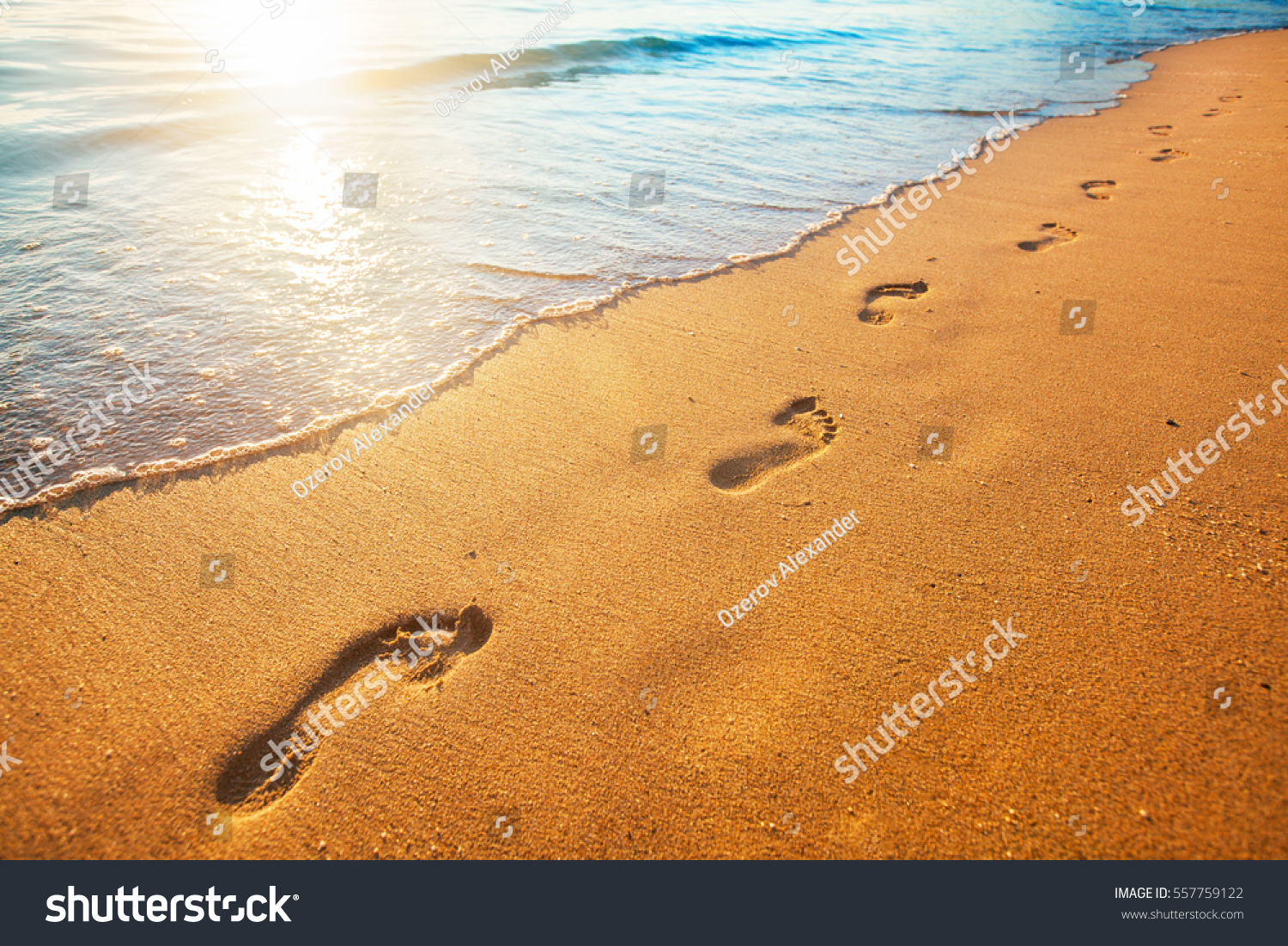 beach  wave and footprints at sunset time
