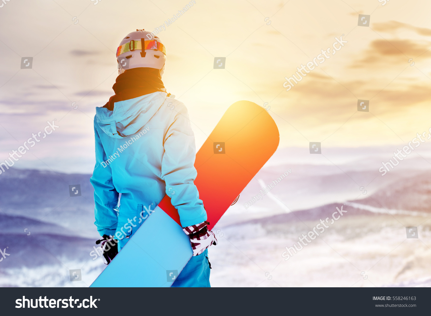 女子滑雪者站在日出背景下的山顶上站着滑雪板。 Sheregesh滑雪胜地