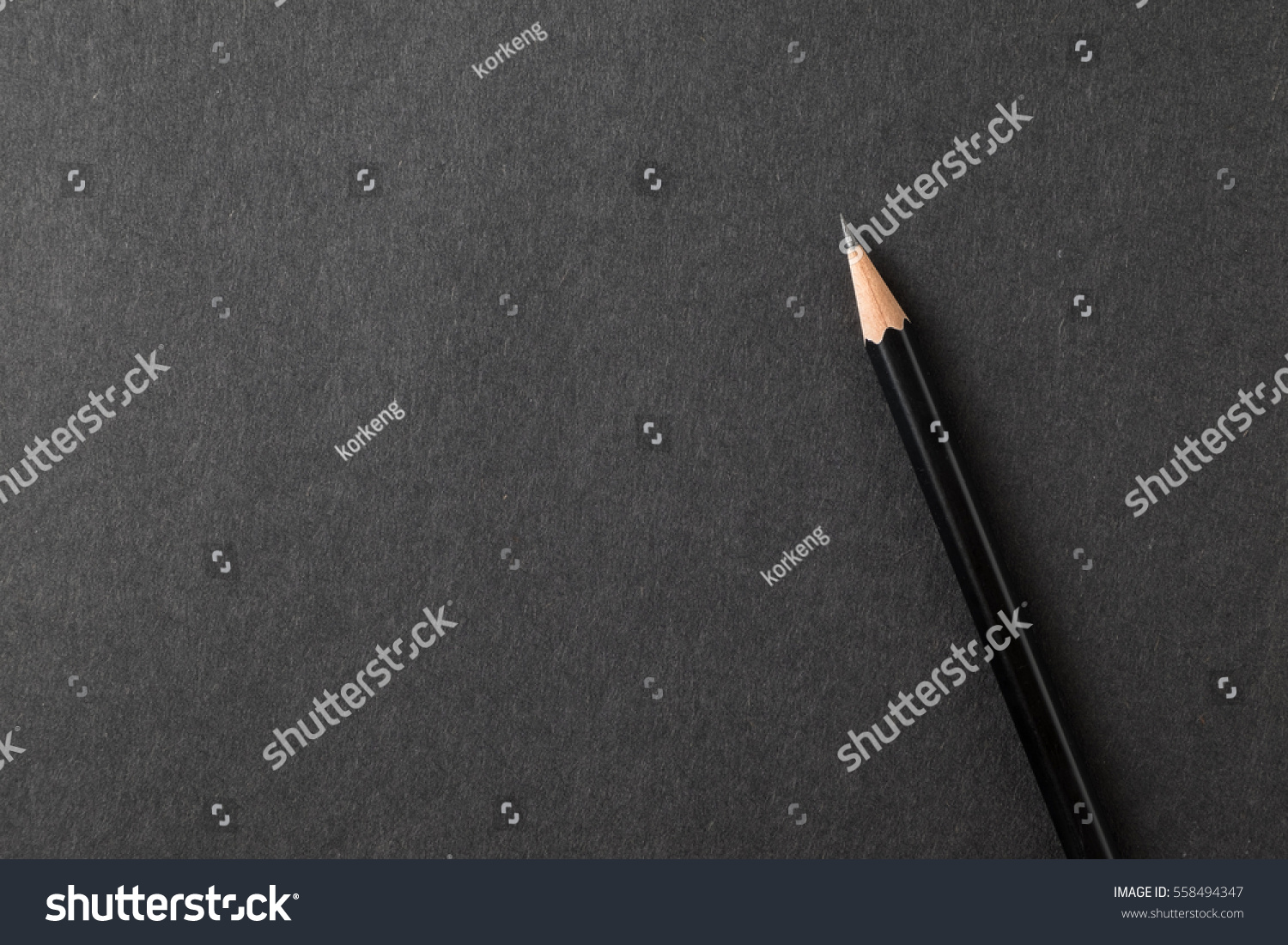 Top view closeup pencil on black craft paper texture.