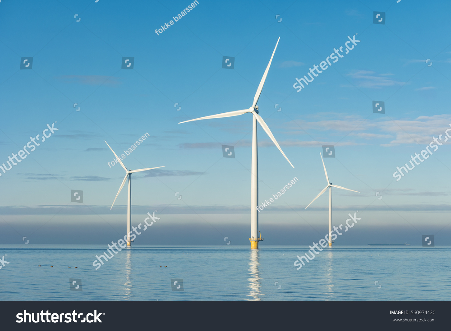 Offshore Windmill farm in the ocean  Westermeerwind park 3 windmills isolated at sea on a beautiful bright day Netherlands Flevoland Noordoostpolder January 2017