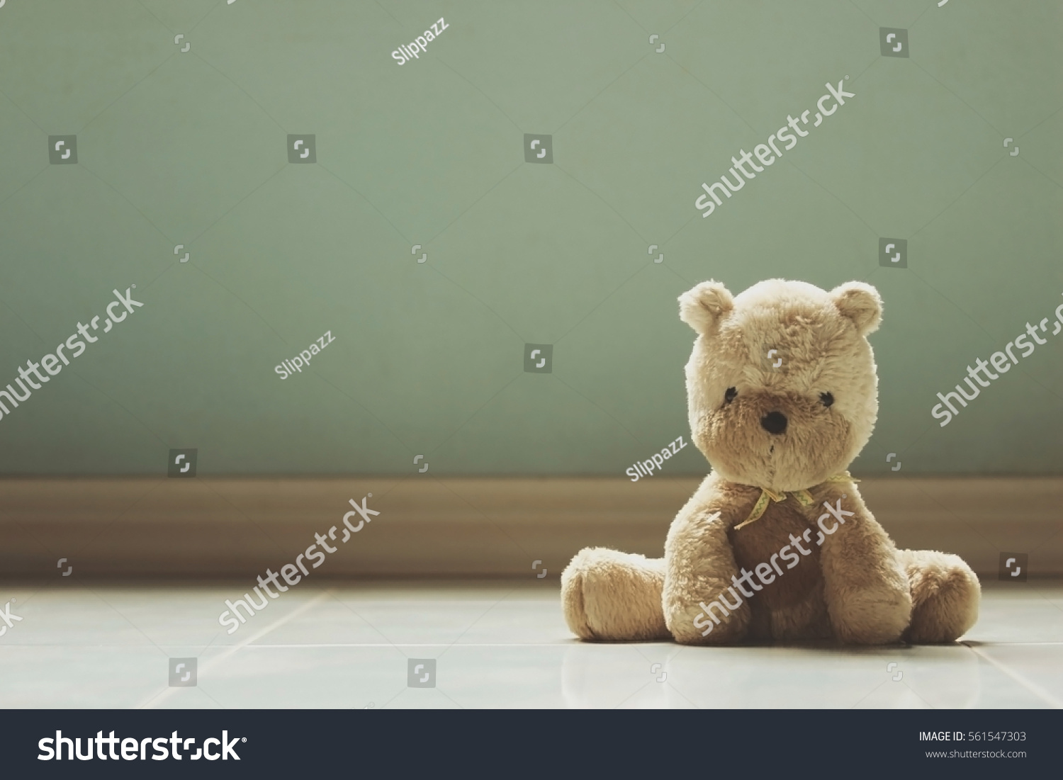 Soft focus of bear doll on floor with photo filter vintage tone.