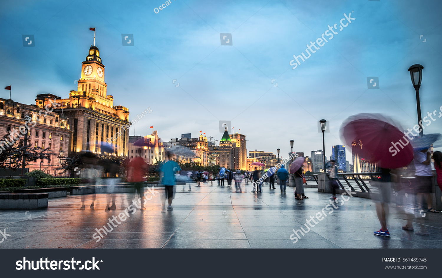People walking on Shanghai's riverfront in the rain carrying umbrellas. 