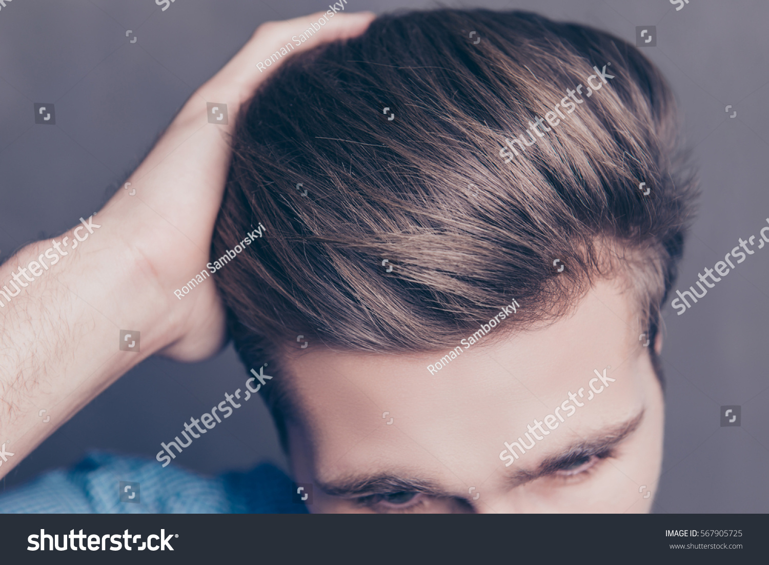 Close up photo of man combing his hair with fingers.