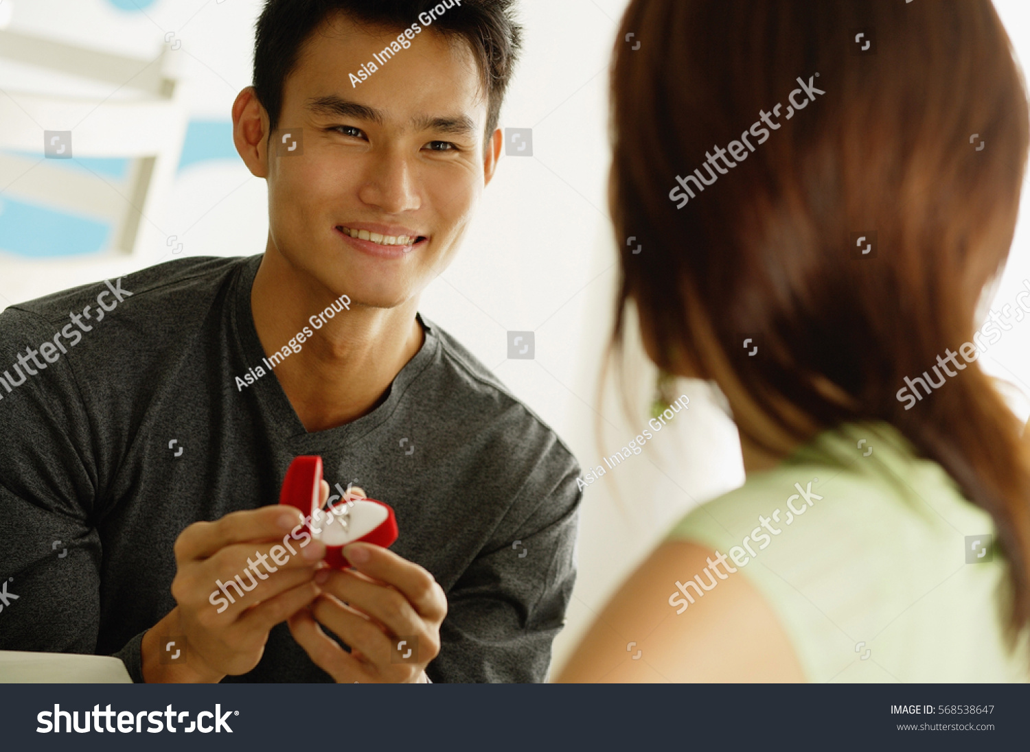 Man proposing to woman  holding ring box