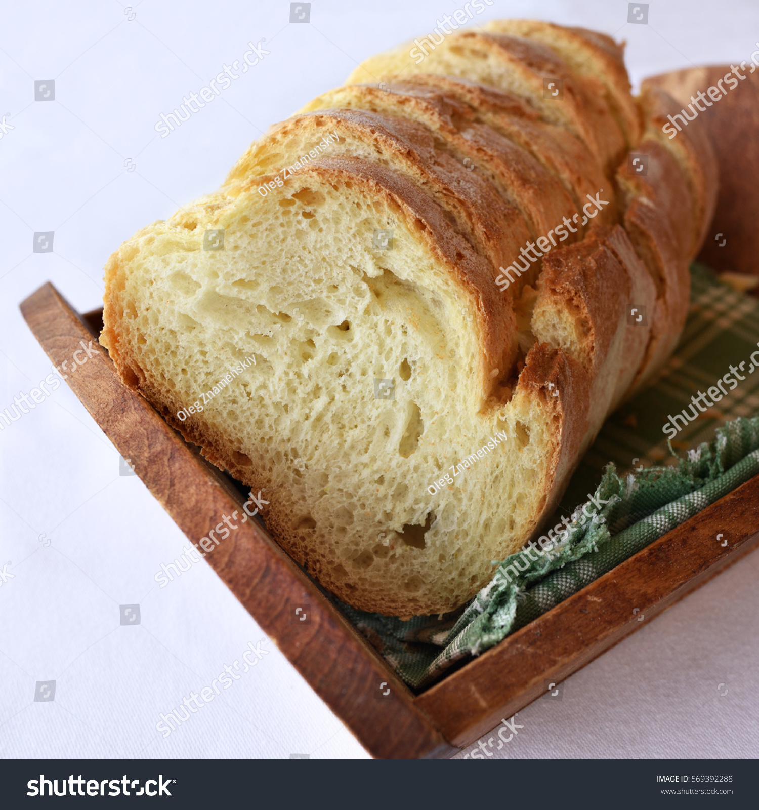 fresh homemade sliced white bread on a wooden tray on the table