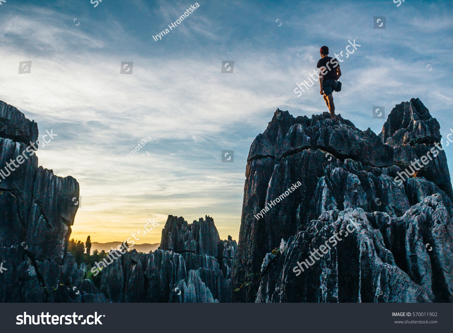 Boy admiring colorful sunset in Stone Forest in Shilin  Yunnan Province  South China  not far from the Kunming. It is world-famous natural area of limestone formations and UNESCO World Heritage Site.