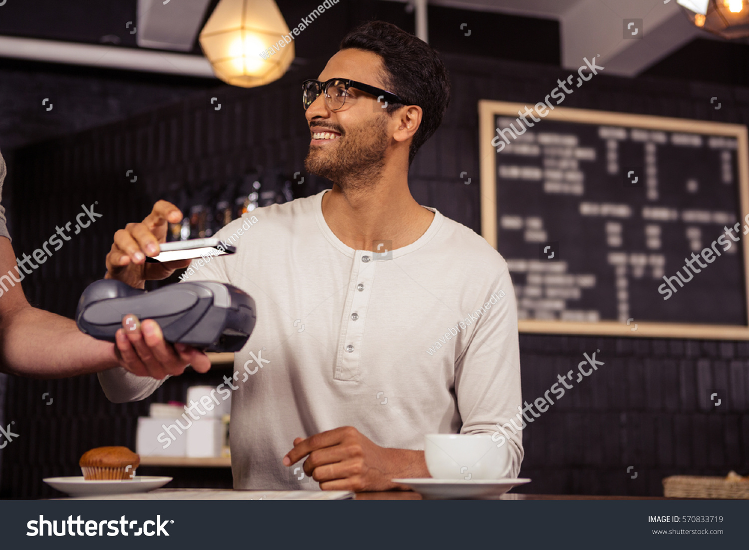 Man using mobile payment in a coffee shop