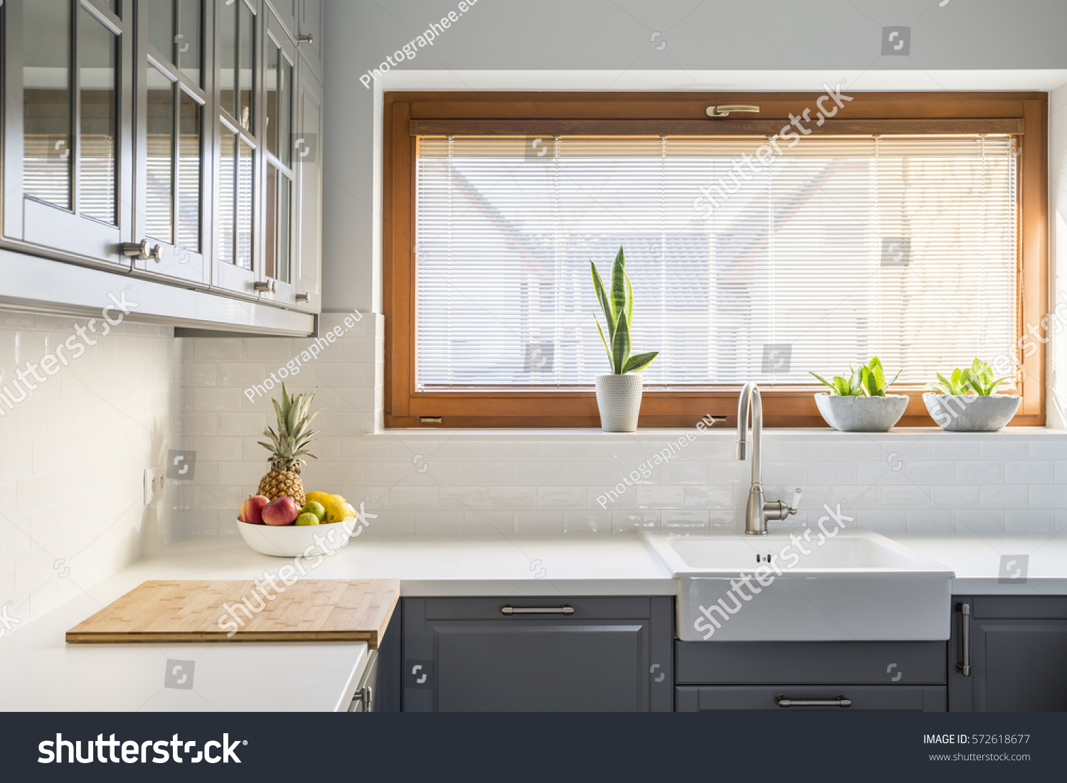 带有白色台面 水槽 窗户和灰色家具的轻厨房