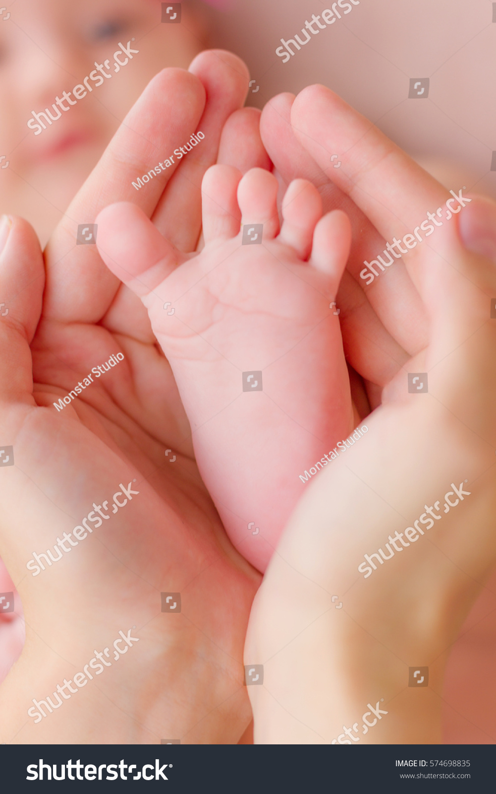 Mother holding her child's small feet in her hands