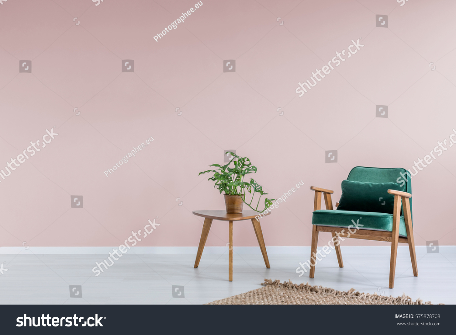 Pink room with green armchair  rug and side table