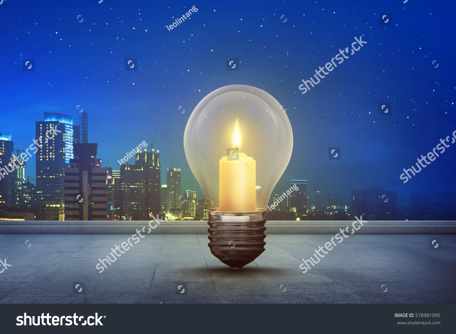 Burning candle inside light bulb on floor with modern city background