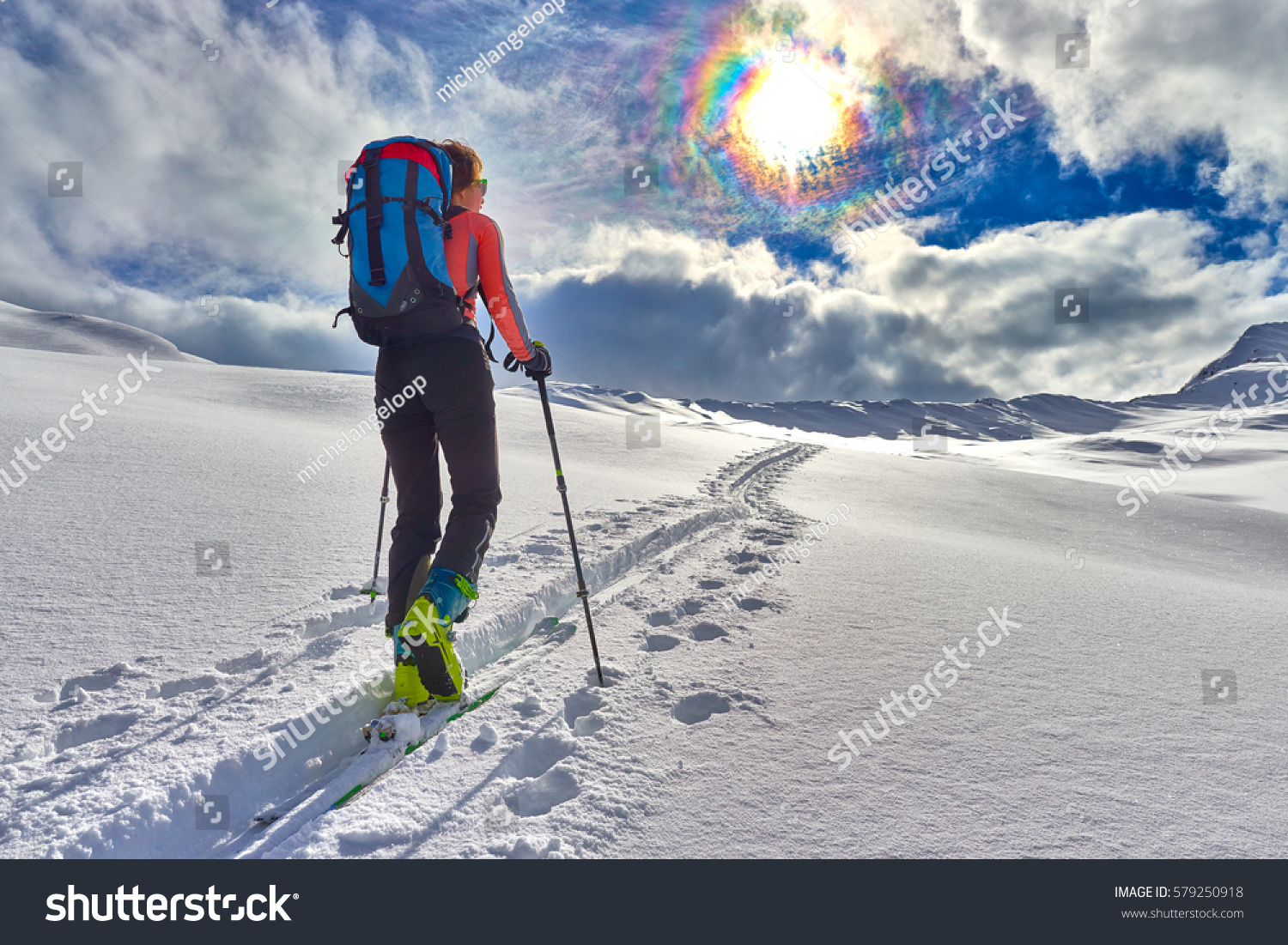 Girl makes ski mountaineering alone toward the mountain pass in a nice track with sealskin