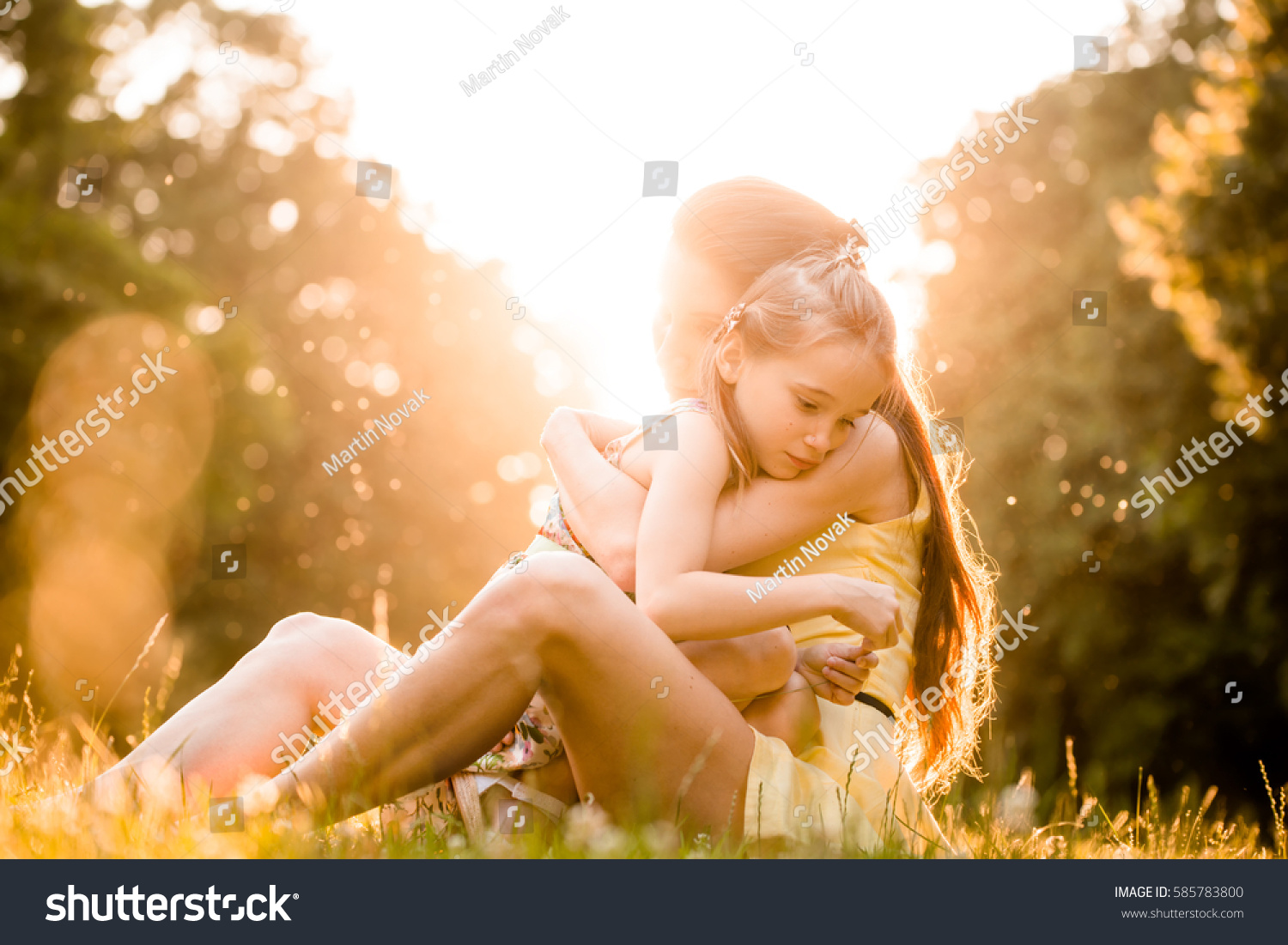Mother is cuddling her worried child outdoor in nature