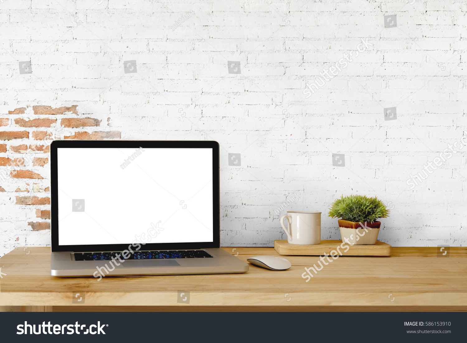 Mock up Blank Screen Laptop on wood table and white brick wall.