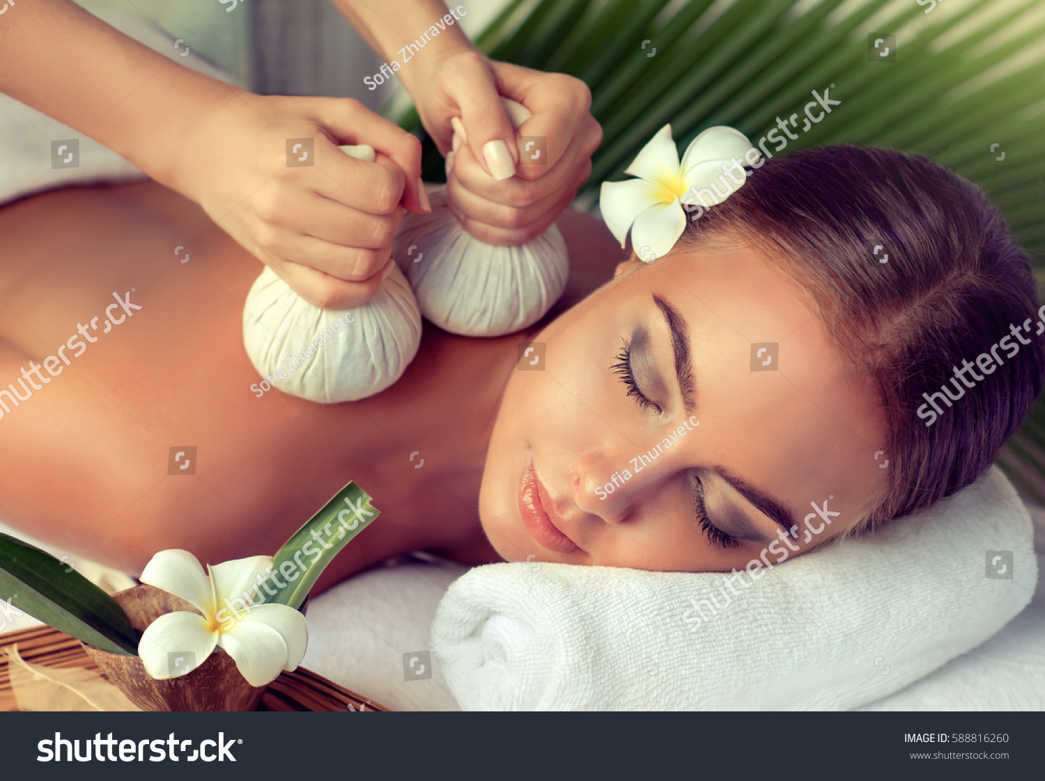 Body care. Spa body massage treatment with hot herbal ball for deep relaxation . Woman having massage in the spa salon