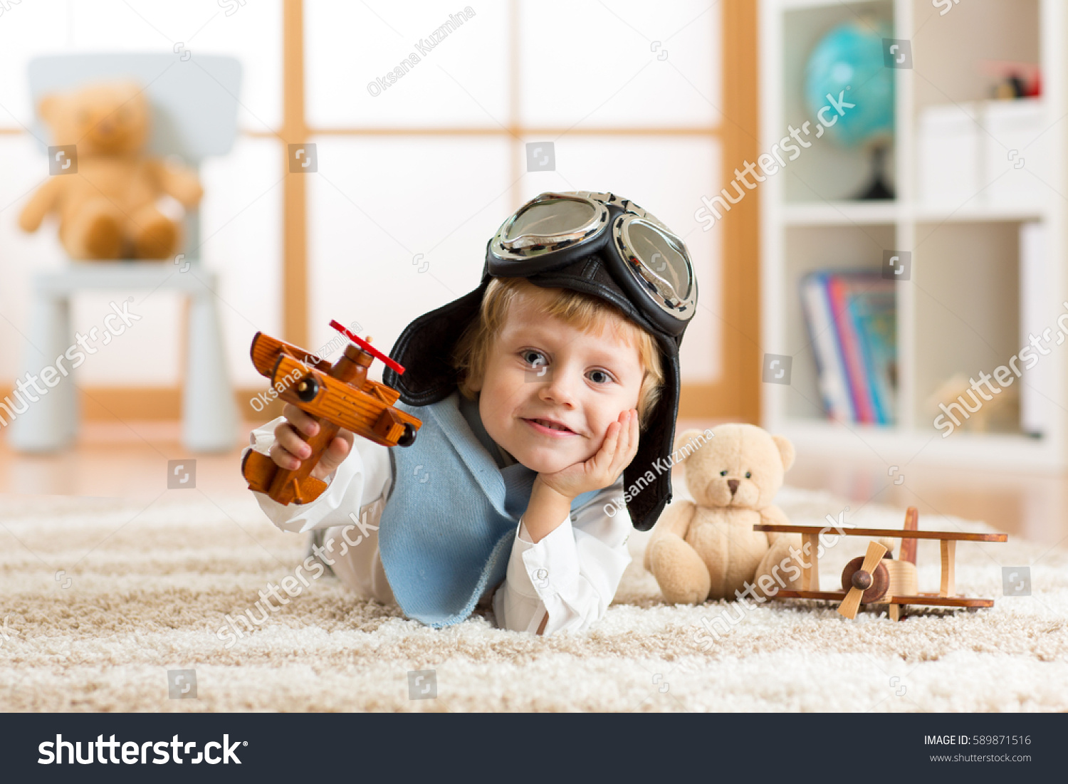 close-up portrait of a little boy playing with a wooden airplane