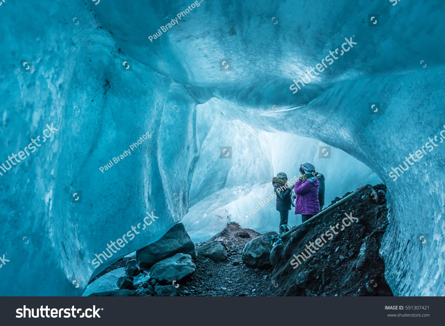 Tourists visit an ice cave under a glacier in Iceland