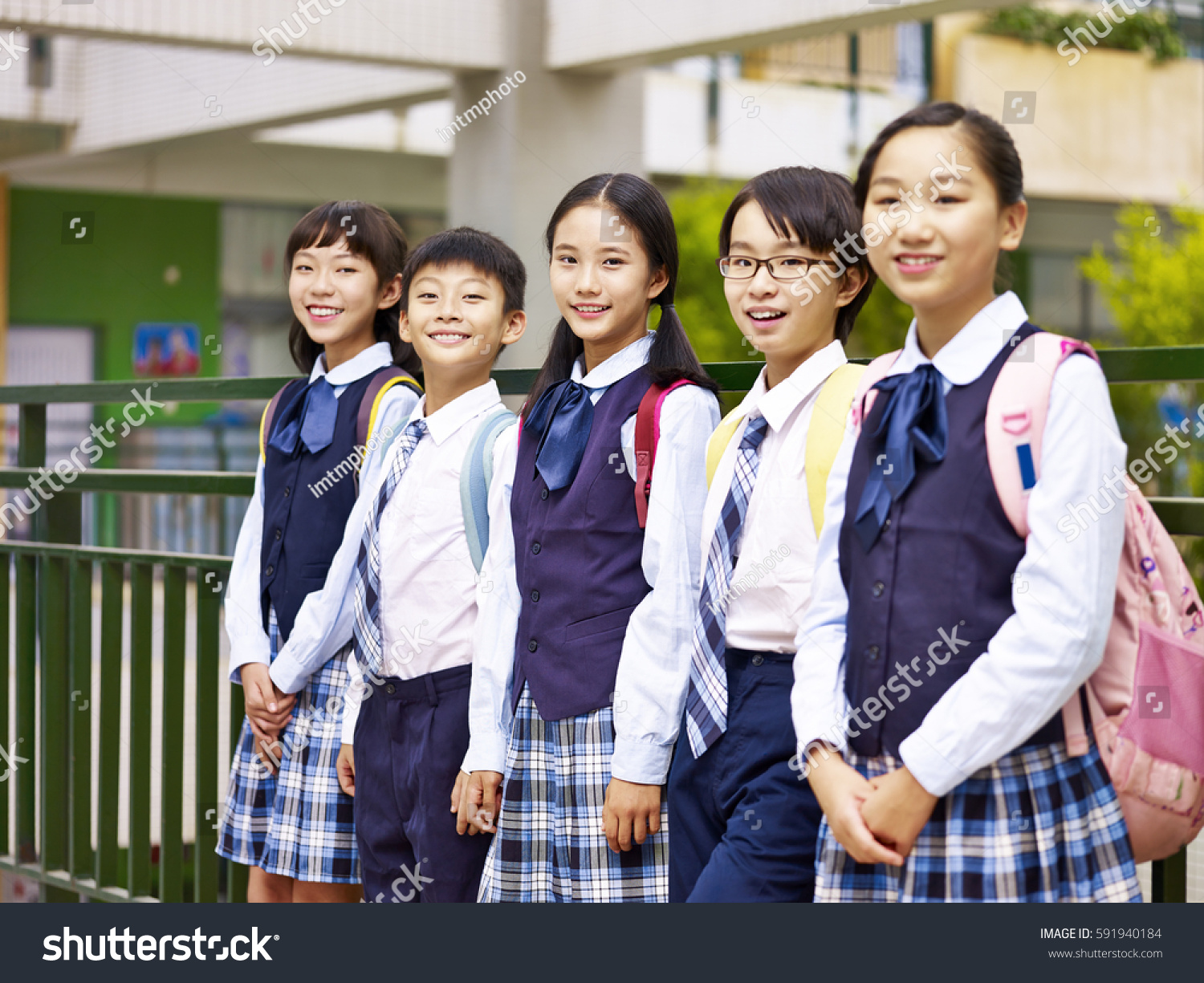 portrait of a group of asian elementary school children looking at camera smiling