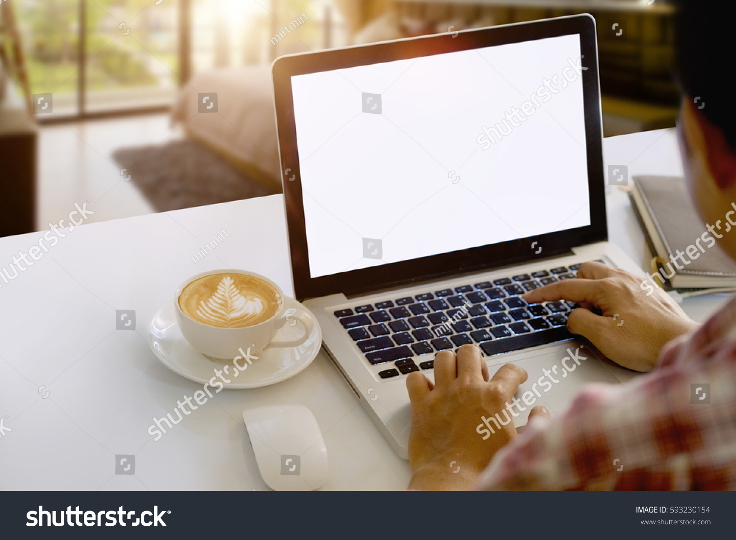 Man working with Blank screen Laptop on desk and workspace in living room.