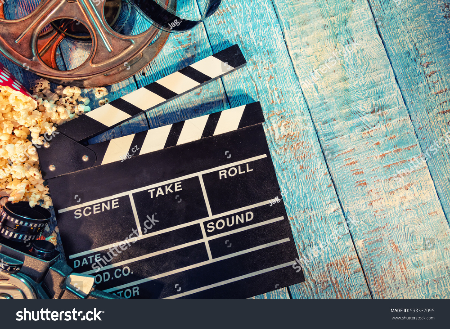 Film camera chalkboard movie camera roll and popcorn on wooden planks. Copyspace for text