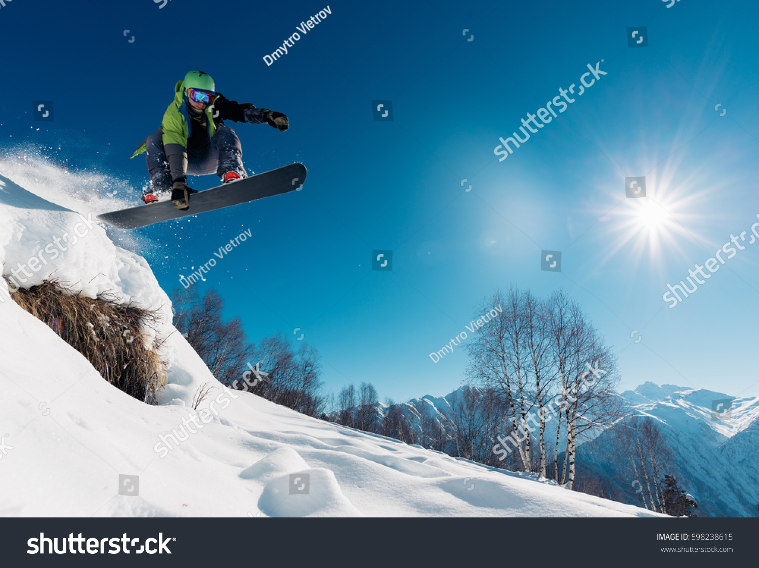 snowboarder is jumping with snowboard from snowhill