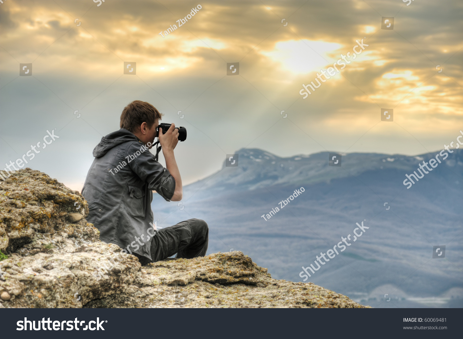 Nature photographer with digital camera on top of the mountain. HDR.
