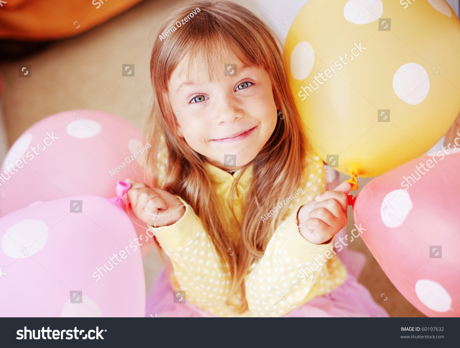 Happy child holding bunch of air balloons